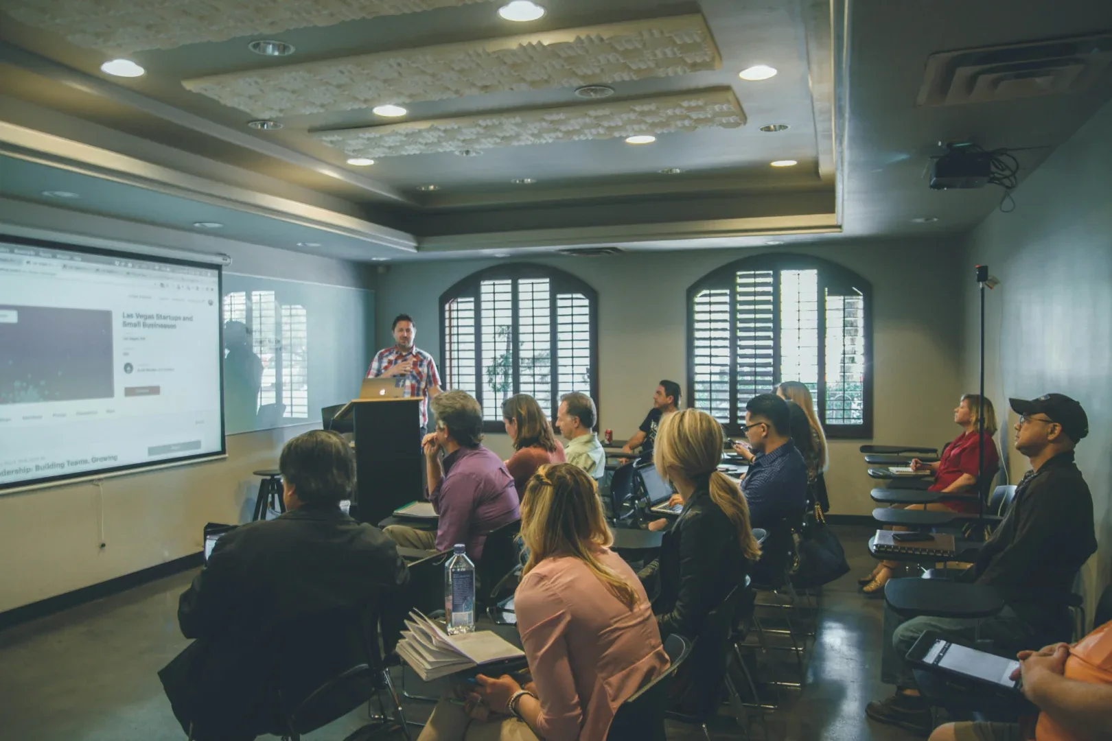 a man standing in front of a group of people in a room