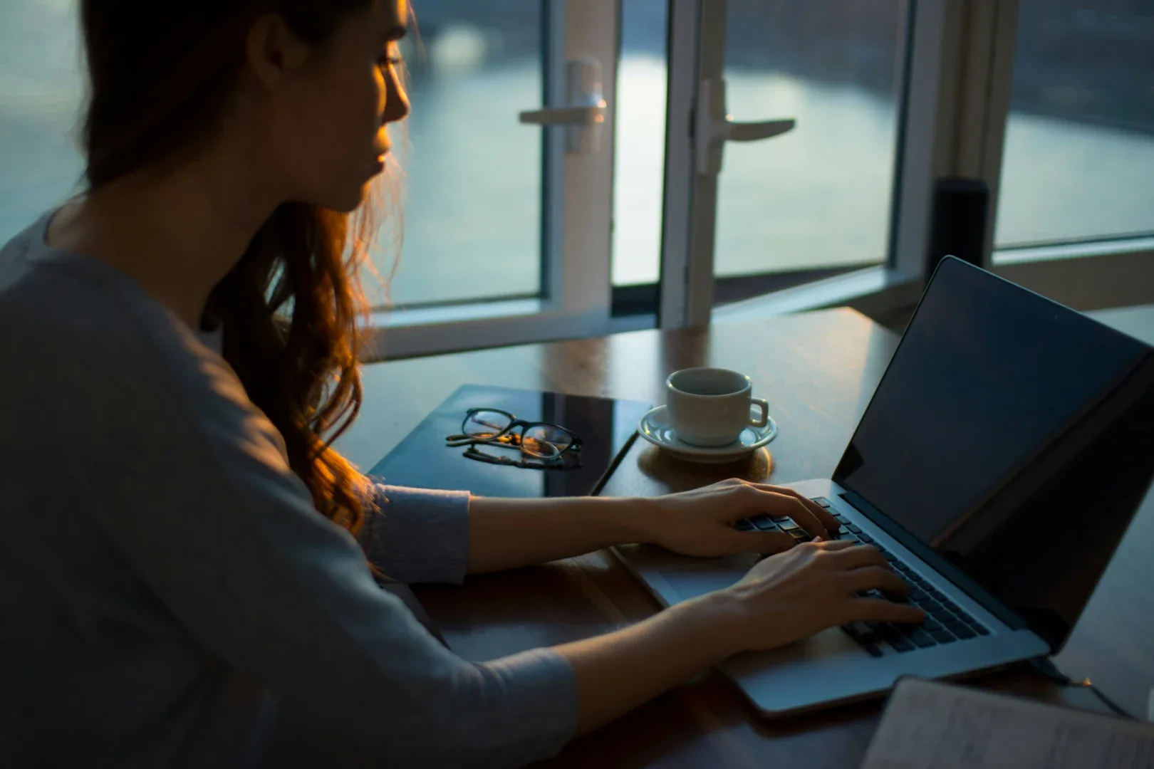 a woman sitting at a desk using a laptop